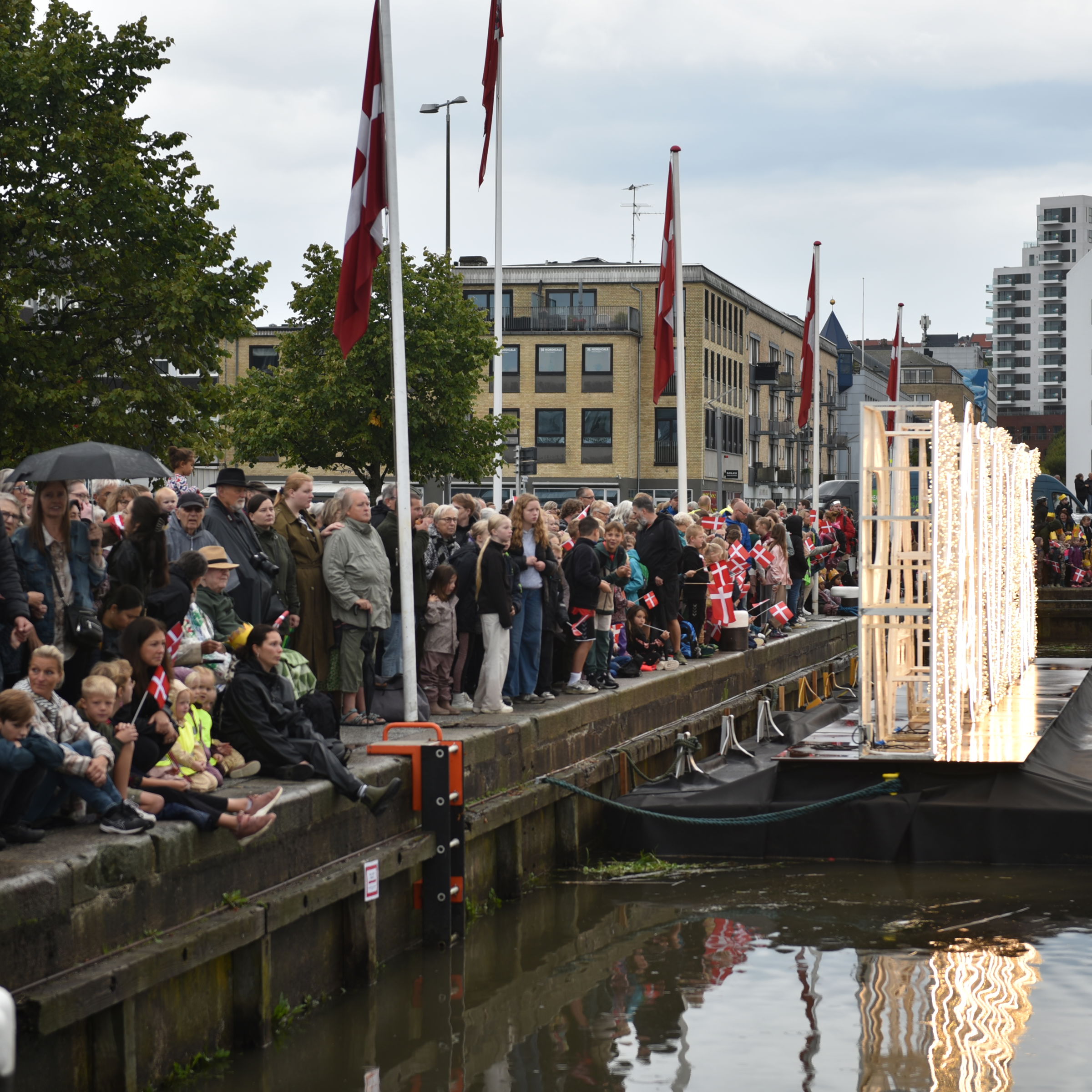 Folk står klar til at modtage Dronningen på havnen