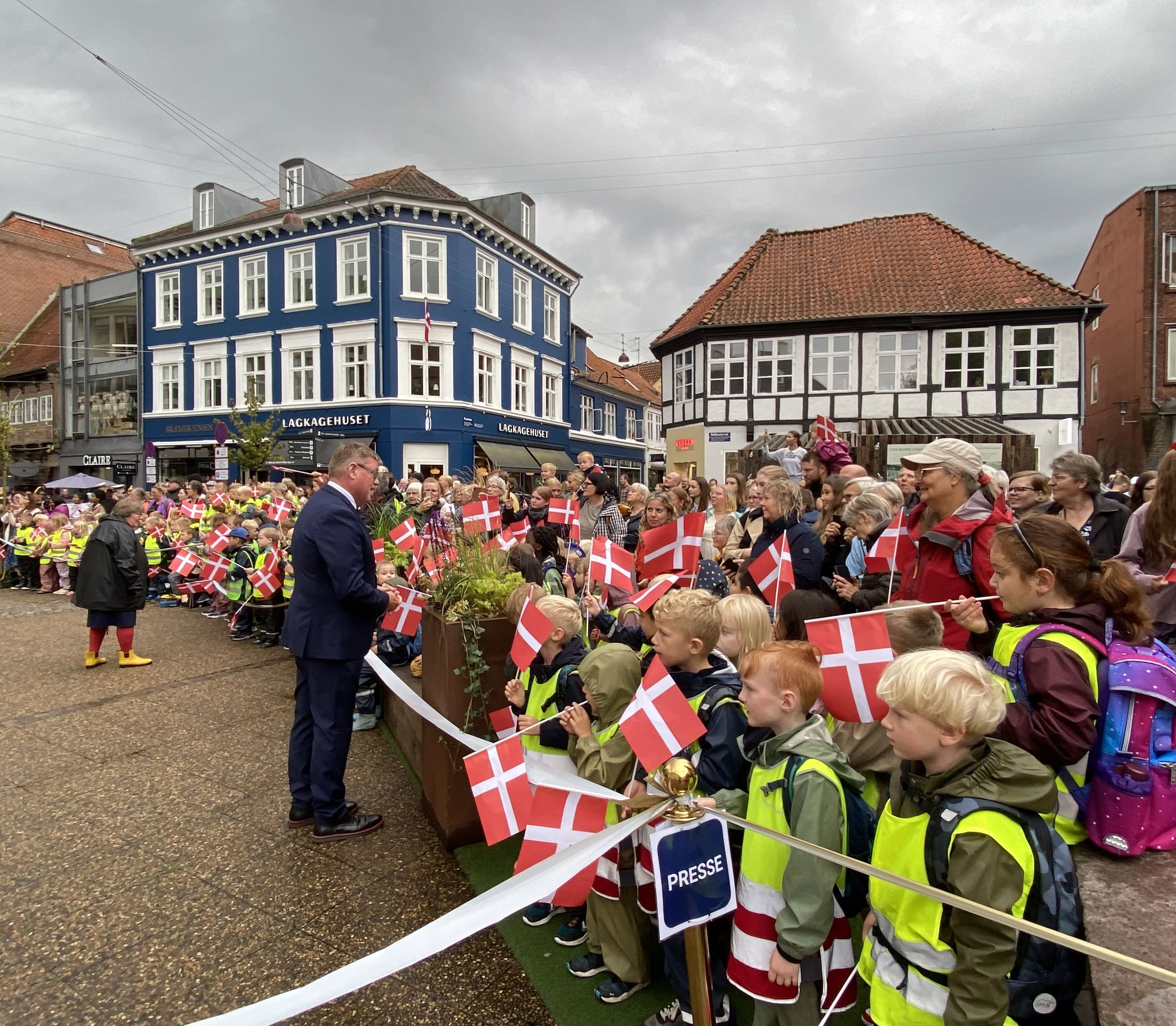 Borgmesteren hilser på folk, som står klar til at modtage Dronningen på Rådhustorvet.